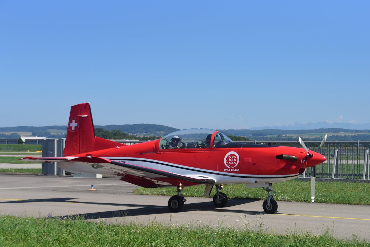 Colorful Swiss PC-7 training aircraft on runway at Payerne, Switzerland.