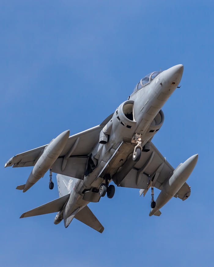 A powerful military jet soars in the blue sky, showcasing its strength and precision.