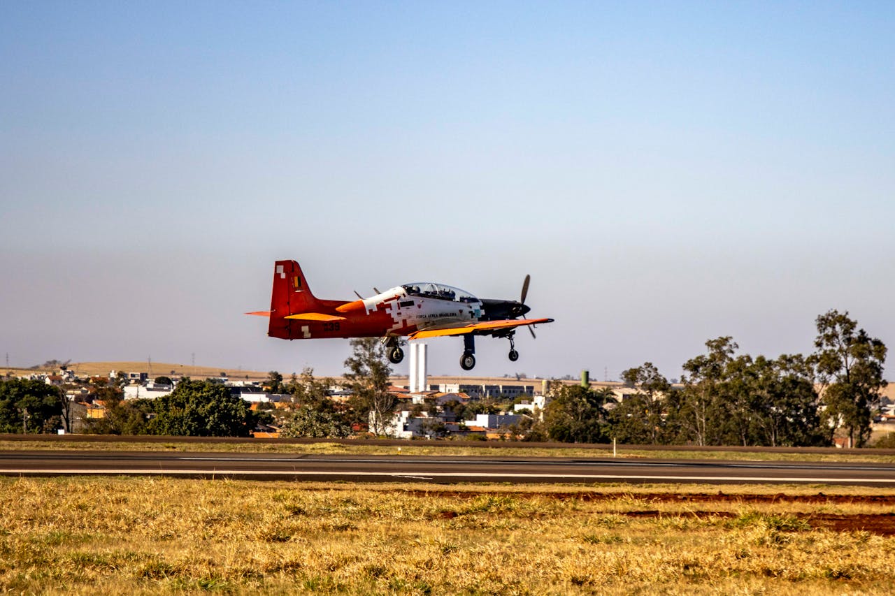 about-01 A red and white aircraft landing at Londrina Airport, Brazil during daytime.