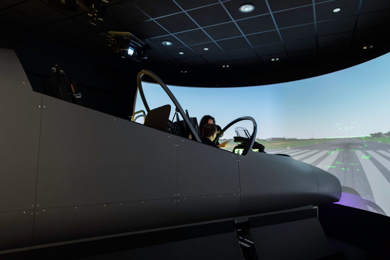 hero-img-02 A female pilot operates a flight simulator in an advanced training facility.