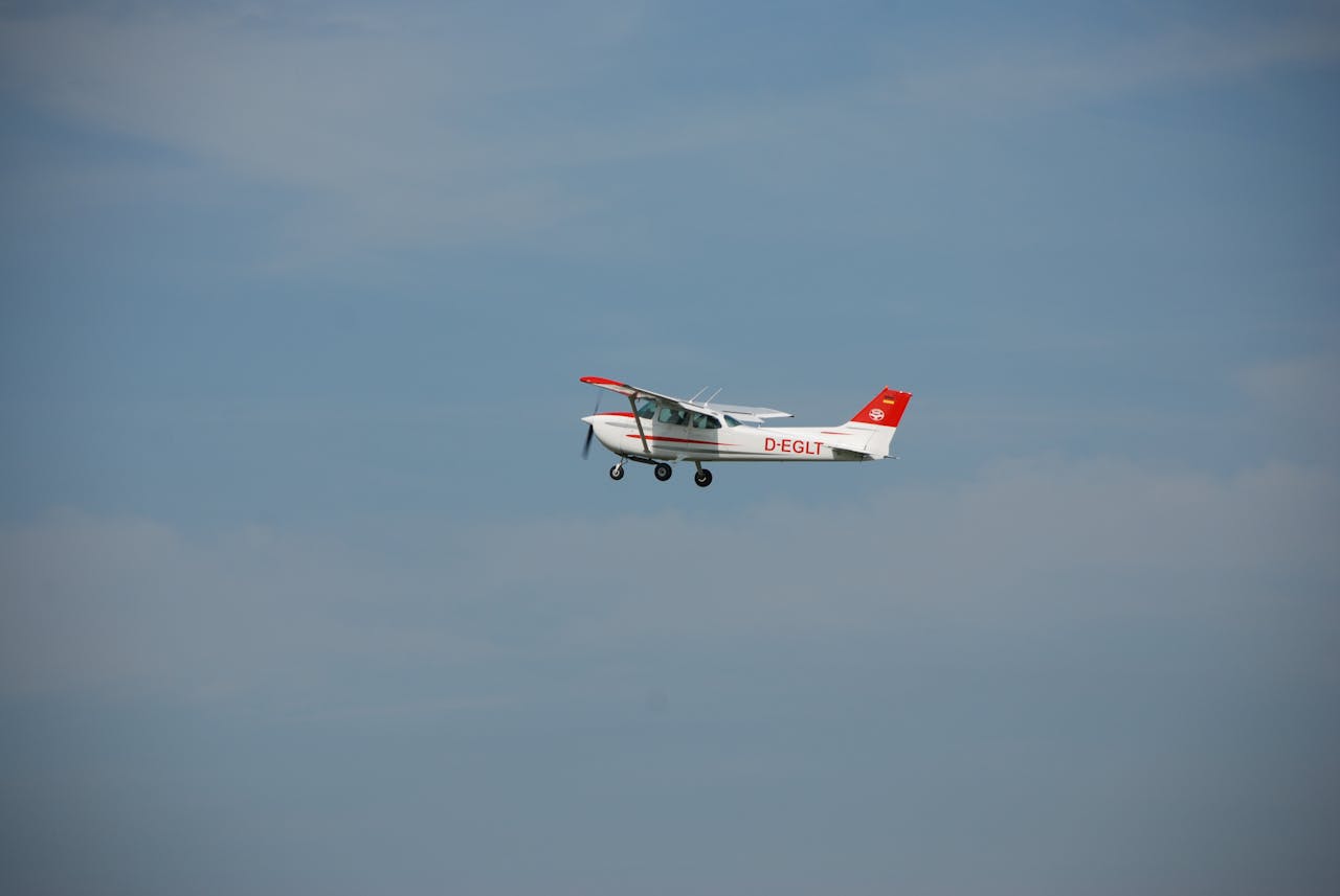 Small aircraft in flight against a clear blue sky, showcasing aviation freedom.